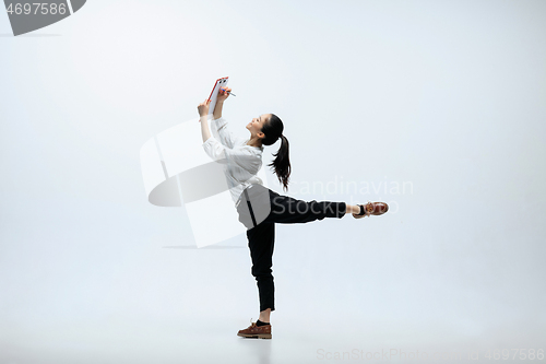 Image of Woman working at office and jumping isolated on studio background