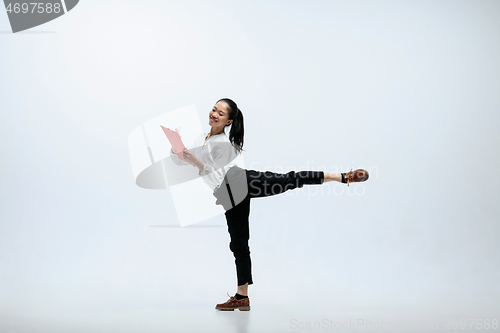Image of Woman working at office and jumping isolated on studio background