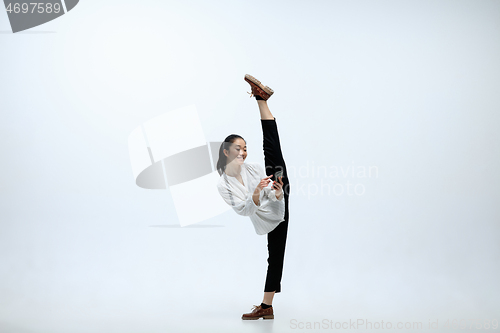 Image of Woman working at office and jumping isolated on studio background