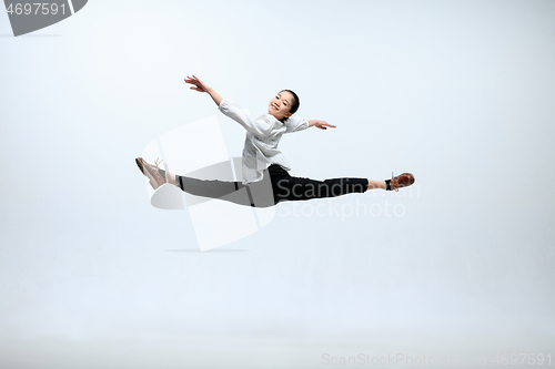 Image of Woman working at office and jumping isolated on studio background