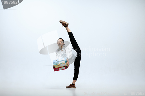 Image of Woman working at office and jumping isolated on studio background