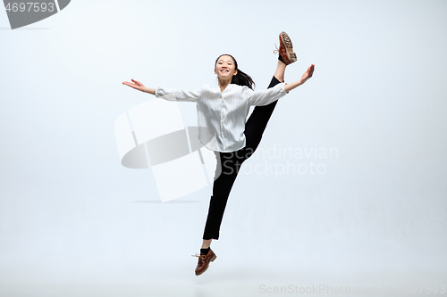 Image of Woman working at office and jumping isolated on studio background