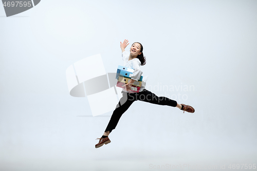 Image of Woman working at office and jumping isolated on studio background