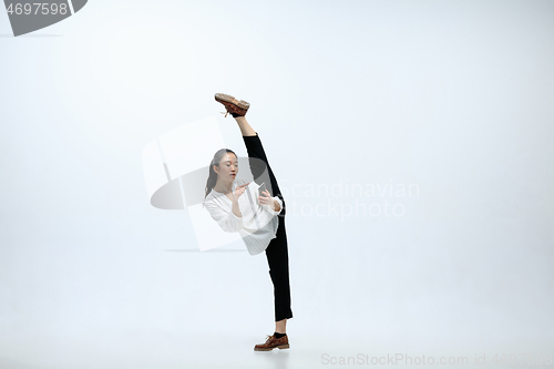 Image of Woman working at office and jumping isolated on studio background