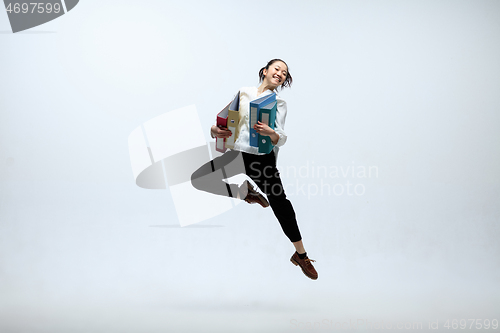 Image of Woman working at office and jumping isolated on studio background