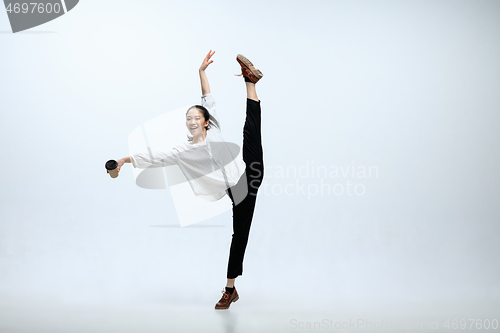 Image of Woman working at office and jumping isolated on studio background