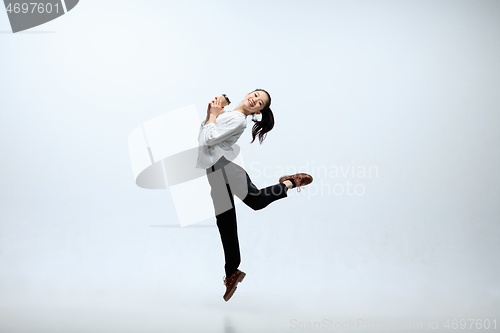 Image of Woman working at office and jumping isolated on studio background