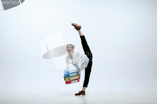 Image of Woman working at office and jumping isolated on studio background