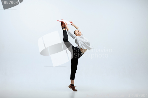 Image of Woman working at office and jumping isolated on studio background