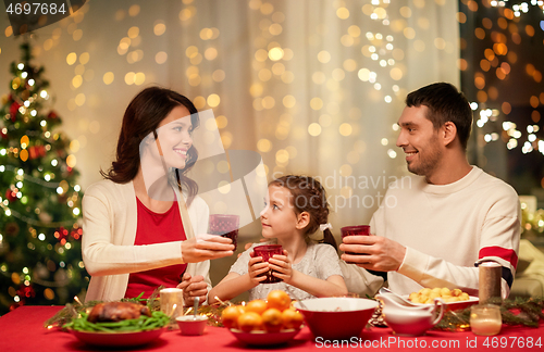 Image of happy family having christmas dinner at home