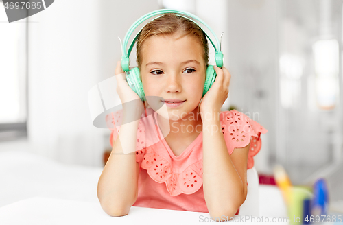 Image of girl in headphones listening to music at home
