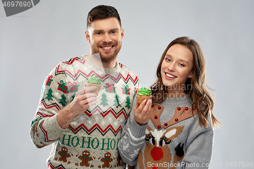 Image of couple with cupcakes in ugly christmas sweaters