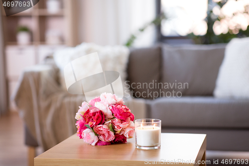 Image of burning fragrance candle and flower bunch at home