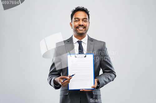 Image of indian businessman with contract on clipboard