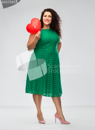 Image of happy woman holding red heart shaped balloon