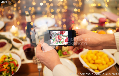 Image of hands photographing food at christmas dinner