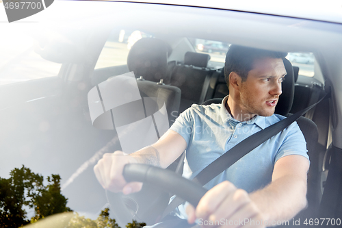 Image of displeased young man or driver driving car