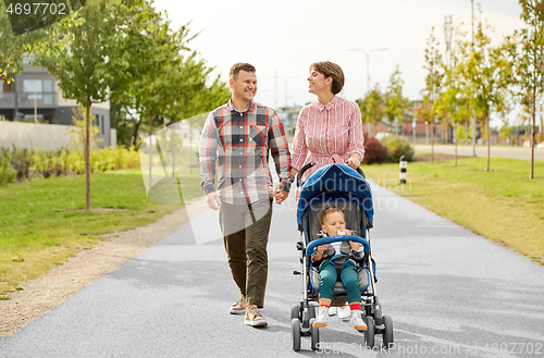 Image of family with baby and stroller walking along city