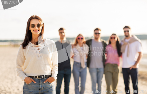 Image of happy woman with friends on beach in summer