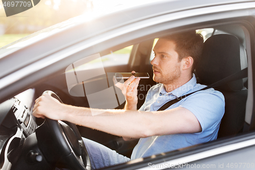 Image of man driving car and recording voice by smartphone