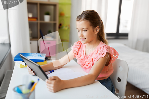 Image of student girl using tablet computer at home