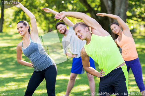 Image of group of happy people exercising at summer park