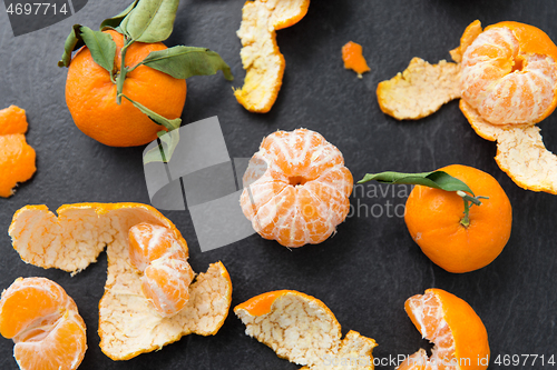 Image of close up of peeled mandarins on slate table top