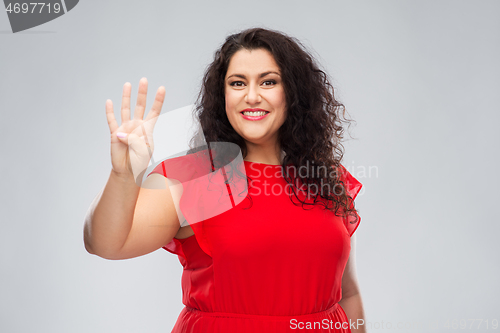 Image of happy woman in red dress showing four fingers