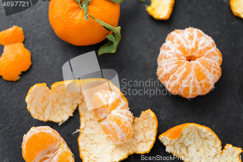 Image of close up of peeled mandarins on slate table top