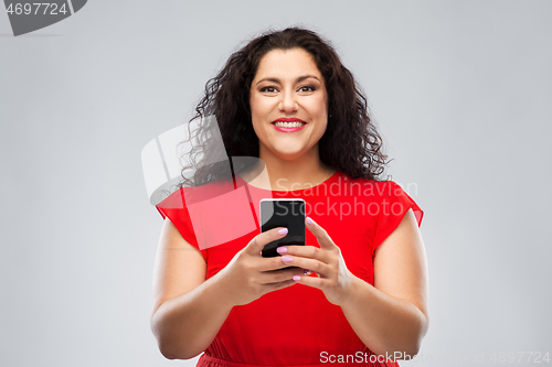 Image of happy woman in red dress using smartphone