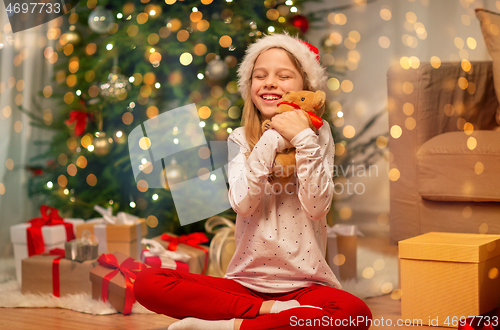 Image of smiling girl in santa hat with christmas gift