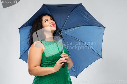 Image of happy woman in green dress with blue umbrella