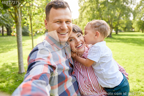 Image of happy family taking selfie at summer park