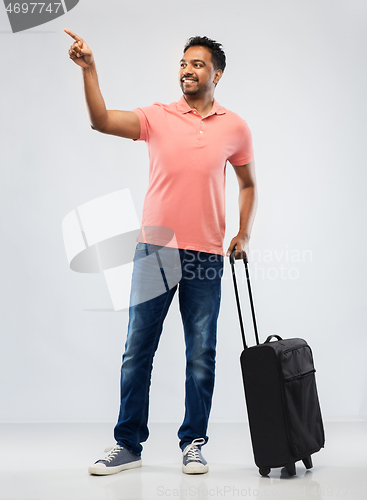 Image of smiling indian man in polo shirt with travel bag