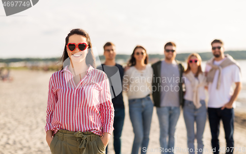 Image of happy woman with friends on beach in summer