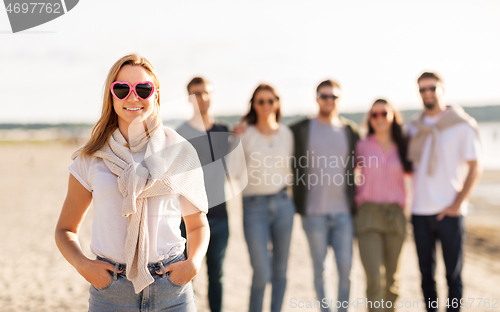 Image of happy woman with friends on beach in summer