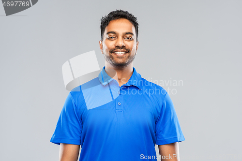 Image of indian man in blue polo shirt over gray background