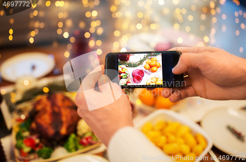 Image of hands photographing food at christmas dinner