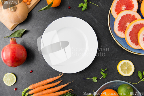 Image of plate, vegetables and fruits on on slate table