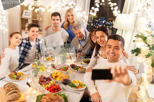 Image of family having dinner party and taking selfie