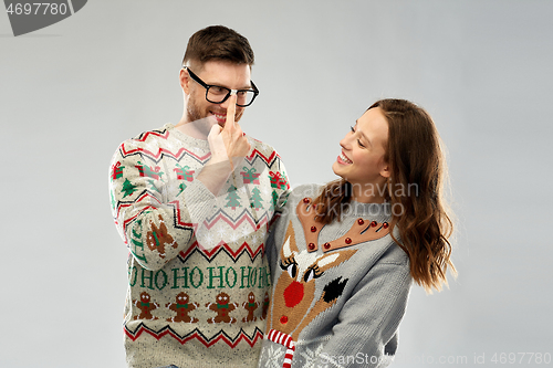 Image of happy couple at christmas ugly sweater party