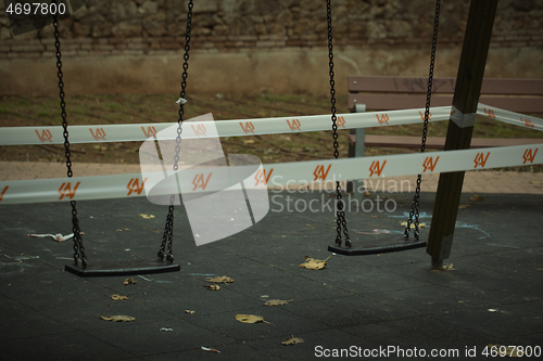 Image of Set of two swings cordoned off on a playground