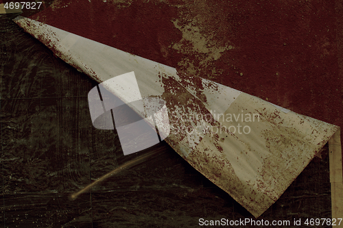 Image of Edge of a peeling poster on a red wall