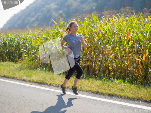 Image of woman jogging along a country road