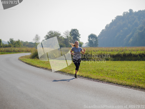 Image of woman jogging along a country road