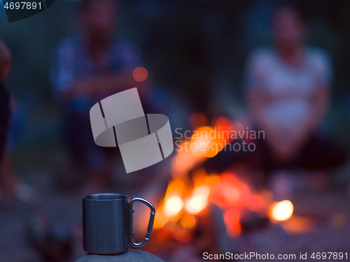 Image of young friends relaxing around campfire