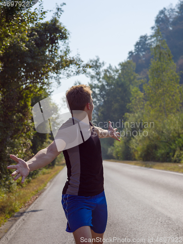 Image of man jogging along a country road