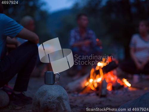 Image of young friends relaxing around campfire