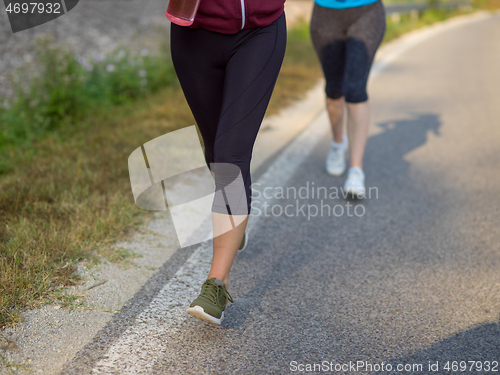 Image of women jogging along a country road