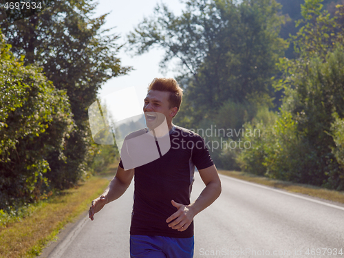 Image of man jogging along a country road